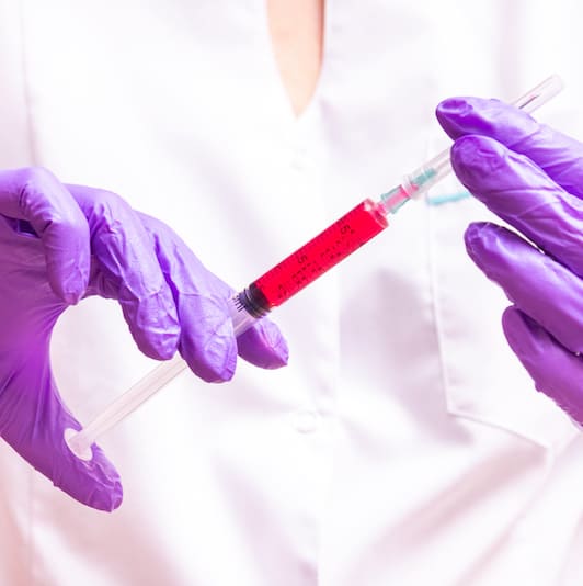 Woman hand holding syringe and ampule